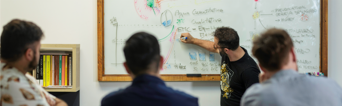 Instructor de Onelli Lab explica en el tablero a un grupo de alumnos